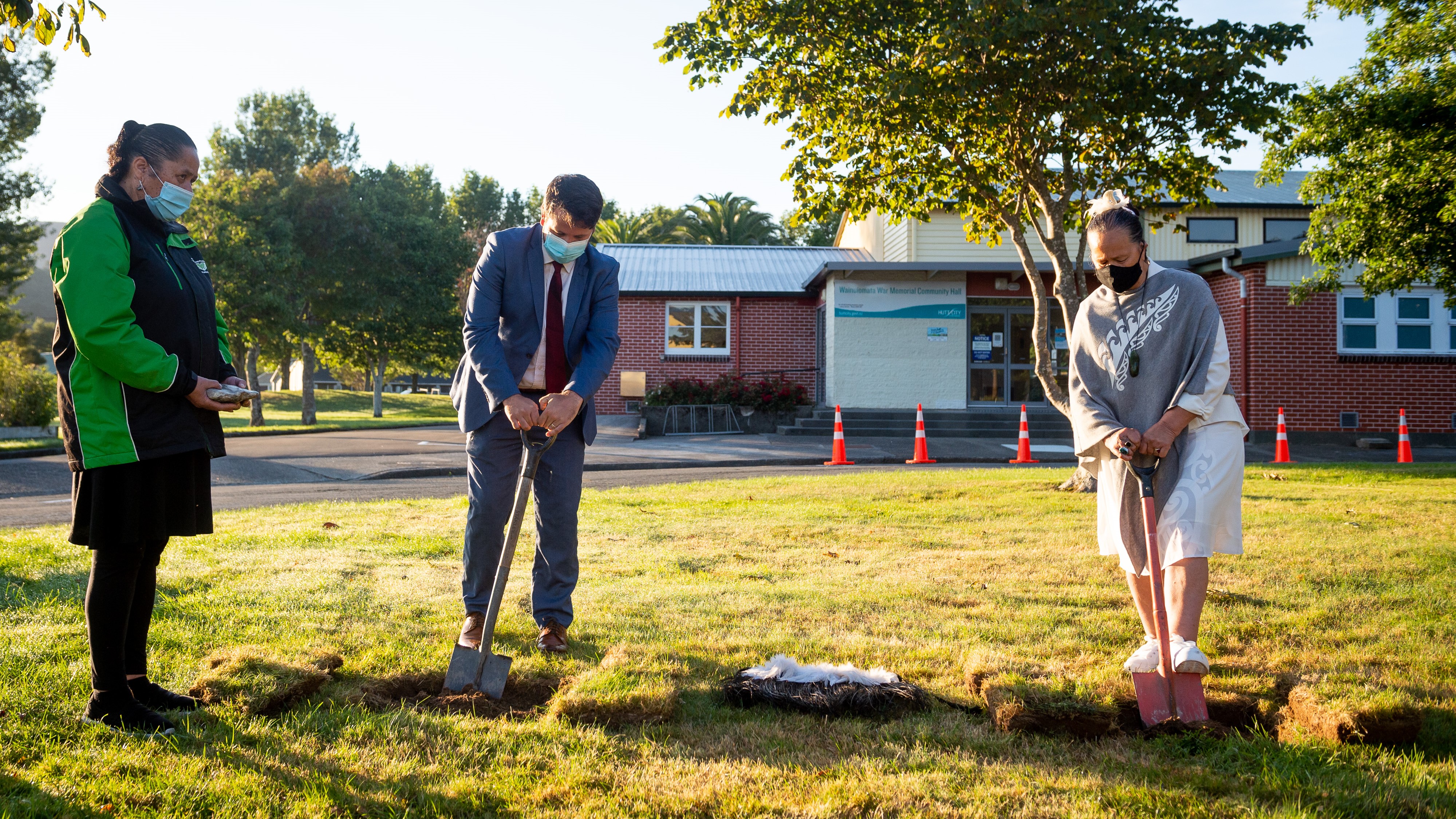 Lower Hutt Mayor Campbell Barry and Linda Oslen from Wainuiomata Marae turning the soil together on the grass in front of the Wainuiomata Memorial Hall