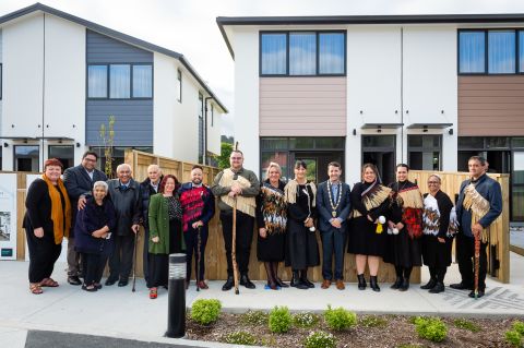 Large number of people standing outside a house