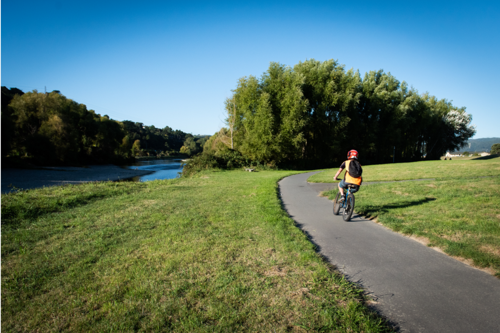 Photo of person cycling by river banner image