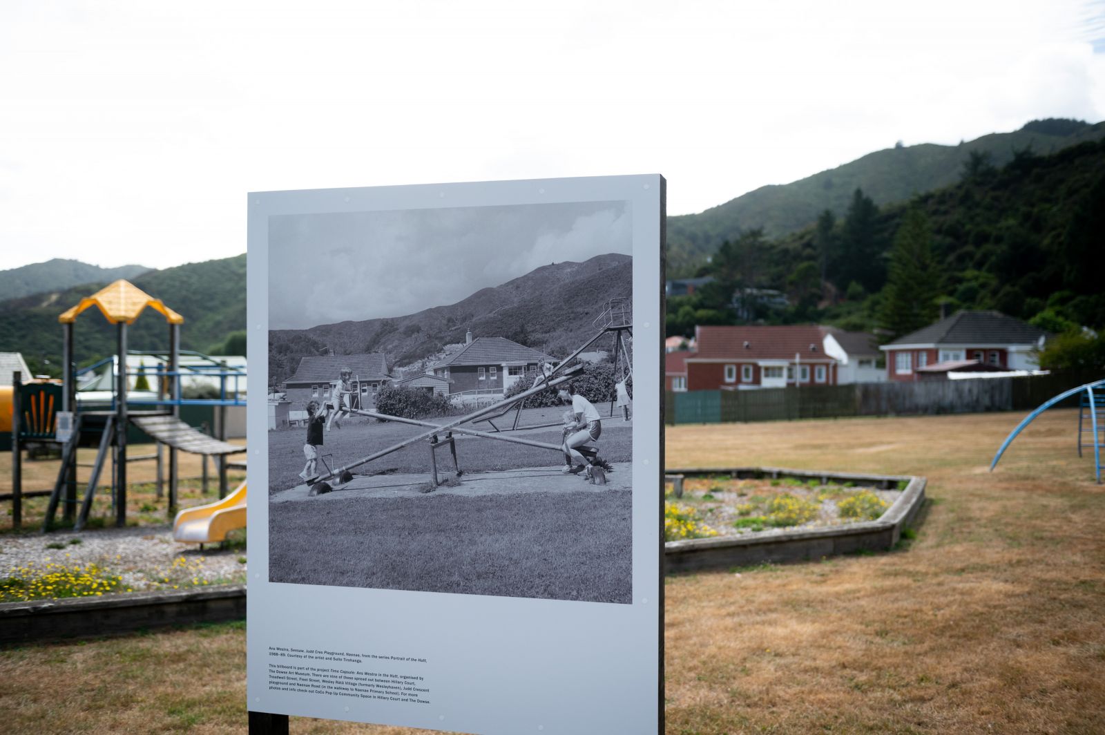 Billboard showing historic photo of a Naenae park displayed at the site of the photo banner image
